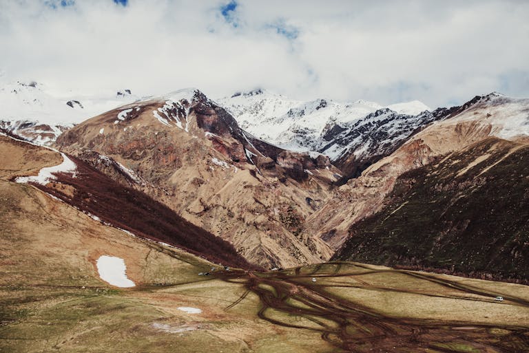 Explore the stunning snow-capped peaks of Mount Kazbek in Georgia with this breathtaking landscape.
