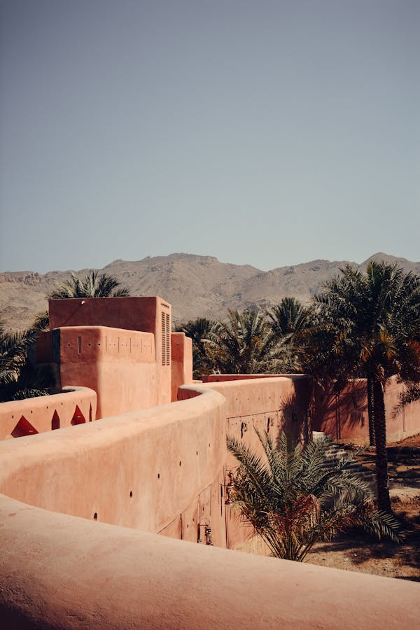 Authentic view of historic architecture surrounded by palm trees in Nizwa, Oman.